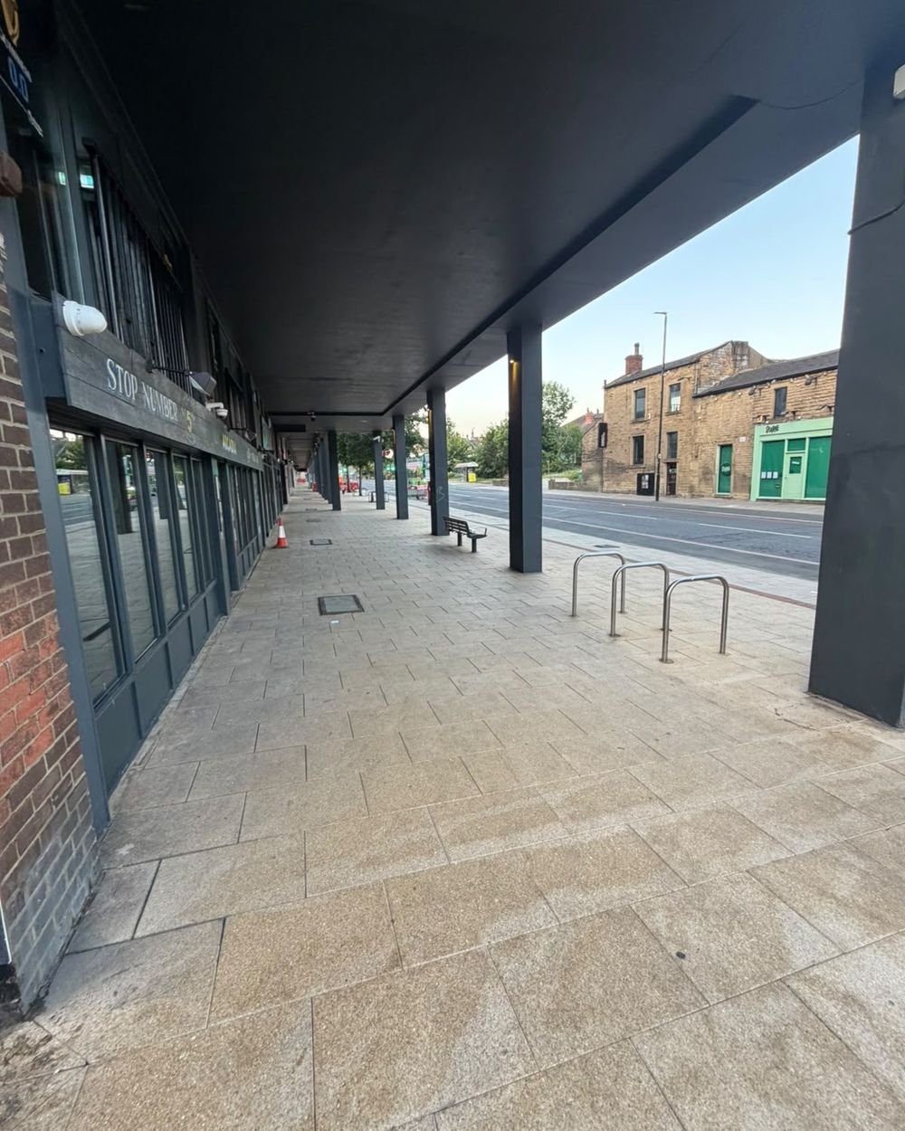 Freshly cleaned stone paving under the colonnade of a glazed commercial frontage in Leeds